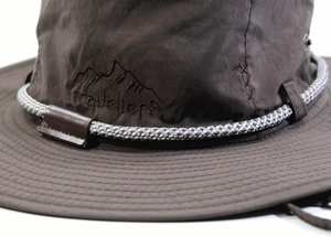 Dettaglio di un cappello da sole con ricamo di montagna e cordino intrecciato