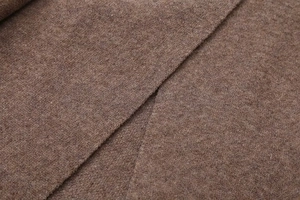 Dettaglio della trama in maglia marrone con fibre di lana di alta qualità e finitura