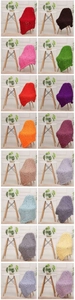Selection of hand-knitted chenille blankets in multiple colors on minimalist chairs