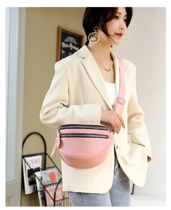 Detail view of pink PU leather crossbody bag featuring double zippers and a wide adjustable strap
