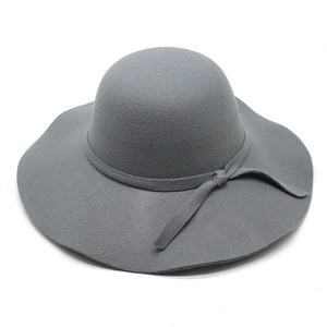 Detailed macro view of dark grey wool felt hat with wavy brim and side bow decoration