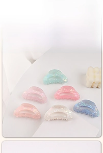 Détail de pinces à cheveux aux tons bonbon avec fini nacré et design ajouré