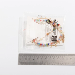 Size reference showing colorful beaded daisy necklace with scale measurement in centimeters