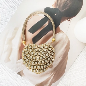 Detailed back view of a heart-shaped gold clutch with sparkling diamonds and crystal handle