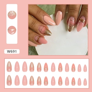 Almond-shaped press-on nails with peach pink gradient and gold glitter accents