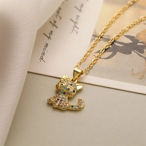 Détail d'un collier pendentif chat doré orné de pierres de zircone colorées