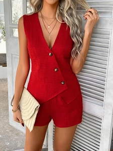 Dettaglio del set in lino rosso con gilet a bottoni scollo a V e pantaloncini a vita alta