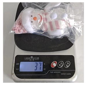 Weight measurement of a pink glowing snowman ornament showing 37g on a digital scale