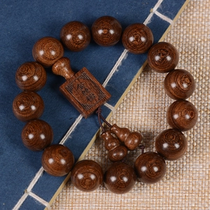Macro shot of Phoebe zhennan wood beads with engraved charm and gourd pendants