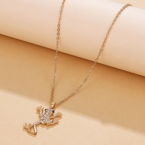 Detailed view of frog pendant with sparkling crystals on gold-plated chain necklace