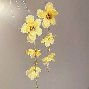 Close-up of yellow organza flower tassel earrings with champagne beads and metal chains