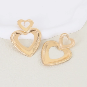 Golden double heart earrings with radial texture design on a clean minimalist background