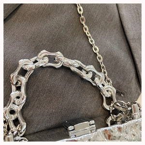 Macro view of silver acrylic box bag featuring chunky chain handle and metallic hardware