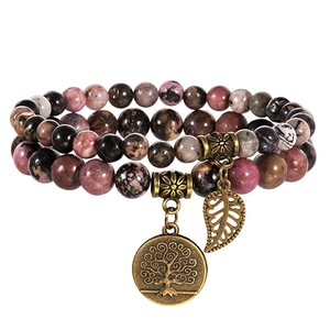 Close-up of triple-layer beaded bracelet with tree of life and leaf charms