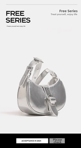Detail of silver metallic hobo bag featuring large round buckle and adjustable shoulder strap