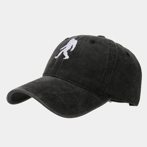 Macro shot of embroidered ape silhouette on vintage washed cotton baseball cap texture
