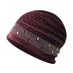 Détail d'un bonnet de luxe en velours bordeaux avec strass et accents métalliques