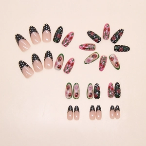 Macro view of almond press-on nails featuring ladybug, cherry, and floral patterns