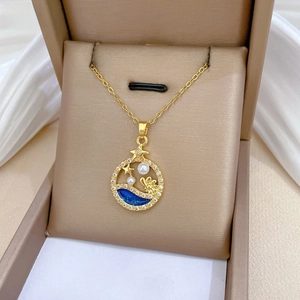 Detail of gold pearl necklace with blue enamel star pendant and zircon ring in jewelry box