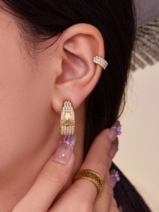Detail of C-shaped flower earrings and ring with gold plating and cubic zirconia