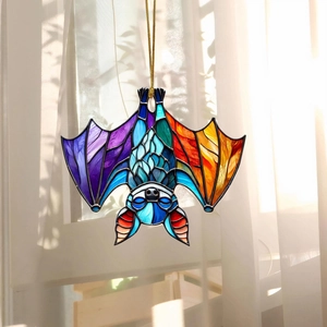 Gothic bat suncatcher in purple and blue stained glass hanging on a sunny window