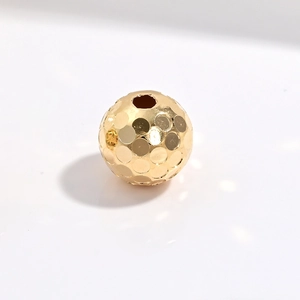 Macro shot of gold-plated S925 sterling silver ball bead with honeycomb textured surface