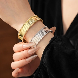 Gros plan de bracelets rainurés or et argent avec pavé de diamants sur le poignet