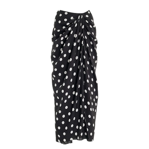Detailed view of a black and white polka dot wrap skirt with elegant waist pleats
