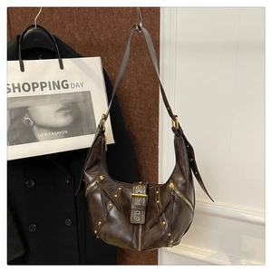 Detail of vintage dark brown faux leather hobo bag with gold rivets and metallic hardware