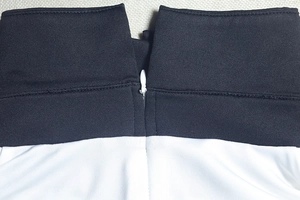 Macro view of seamless waist joint and hidden zipper on black and white knit dress