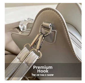 Detail of high-quality silver metal hook and litchi grain leather on gray handbag