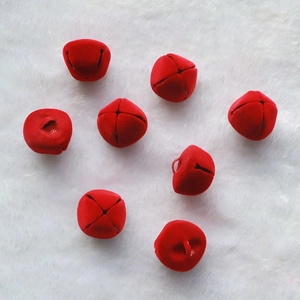 Red 2.5cm flocked Christmas bells with matte texture on white plush background