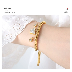Detail of gold beaded bracelet with crystal butterfly charm on model wrist
