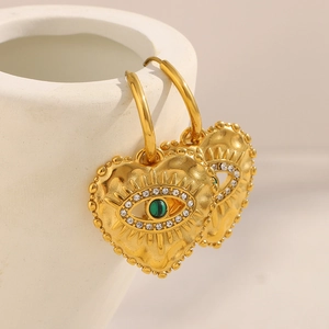 Macro shot of gold heart earrings with emerald eye inlay and micro-pave zircons