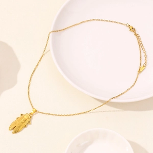 Close-up of golden cicada insect pendant on a fine link chain with adjustable clasp