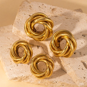 Boucles d'oreilles rondes torsadées en acier inoxydable doré sur un support en pierre
