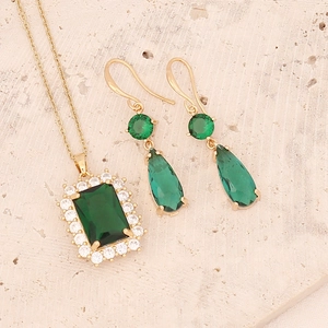 Detailed view of emerald zircon jewelry set with gold necklace and matching drop earrings