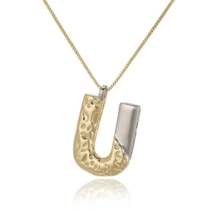 Macro shot of two-tone letter U pendant with hammered gold and smooth silver finish