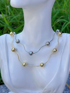 Detail of minimalist 18k gold and silver plated bead necklaces on model bust