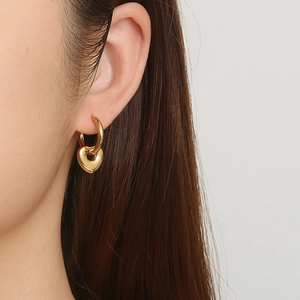 Fashionable 18K gold plated stainless steel hoop earrings with heart pendant on model