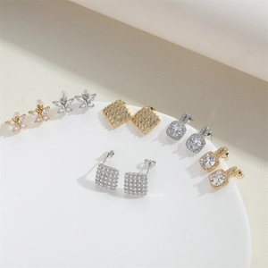 Detailed display of square and butterfly stud earrings with zircon inlay in gold and silver