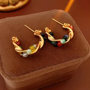 Vintage gold-toned C-shaped earrings with colorful beads on dark velvet box