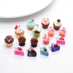 Detail view of 17 miniature resin cake pendants for DIY jewelry on white background