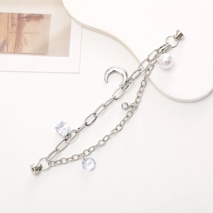 Silver double-layer bracelet with moon, zircon, crystal and pearl charms on white background