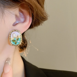 Close-up of vintage floral earrings with pearl tulips and colorful enamel finish