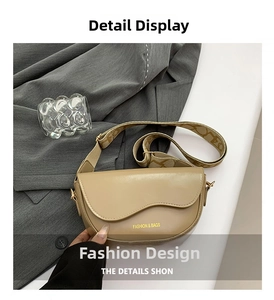 Detail of khaki saddle bag with fashion lettering and wide textured shoulder strap