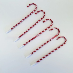 Detail of five candy cane shaped ballpoint pens with classic red and white stripes