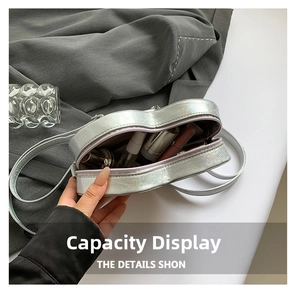 Detail showing the internal storage capacity of the heart-shaped silver metallic crossbody bag