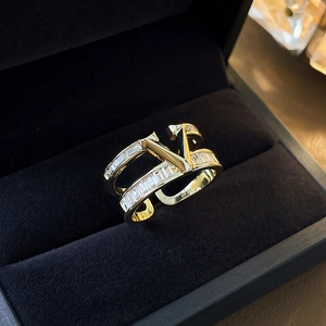 Macro detail of gold plated V-shape ring with rectangular zircon stones on velvet