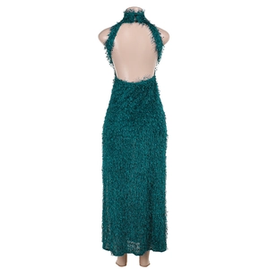 Close-up of halter backless long dress with peacock green fringe texture on a mannequin